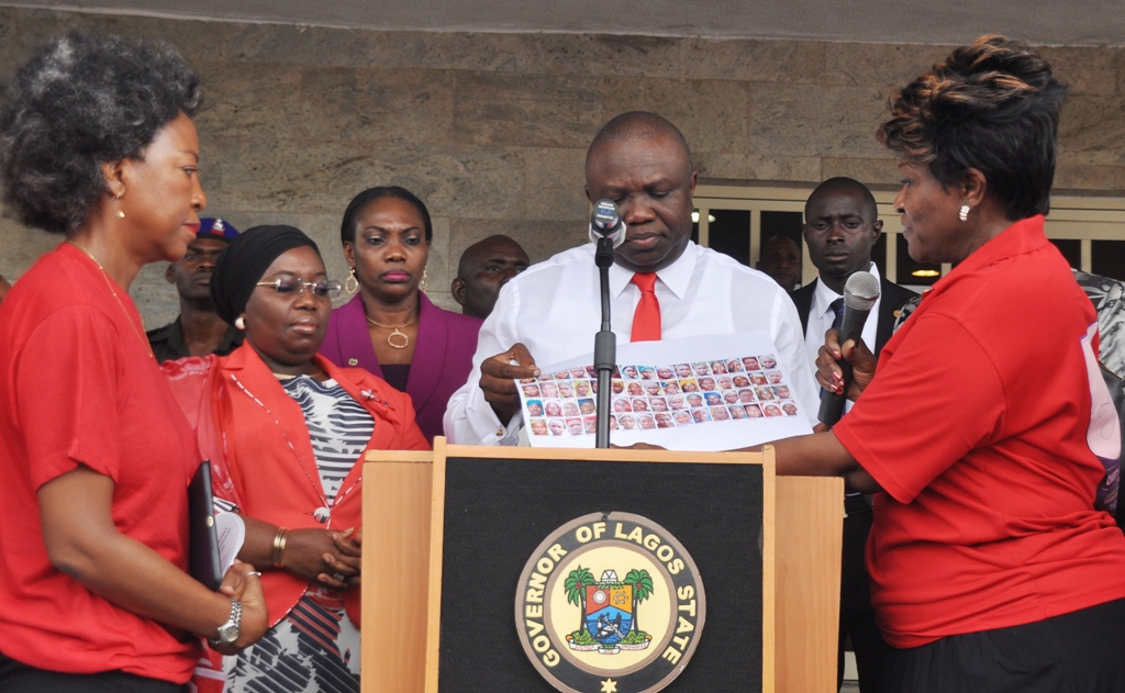 Lagos State Governor, Mr. Akinwunmi Ambode (2nd right) receiving pictures of the over 200 kidnapped Chibok Girls from a member of Bring Back Our Girls Group, Ms. Yemi Ransome-Kuti (right) while the Deputy Governor, Dr. (Mrs.) Oluranti Adebule (2nd left) and Legal Practitioner, Trade Marks & Patents Agents, Mrs. Ayo Obe (left) watch during a solidarity rally by the Group to the Governor, at the Lagos House, Ikeja, on Thursday, August 27, 2015.