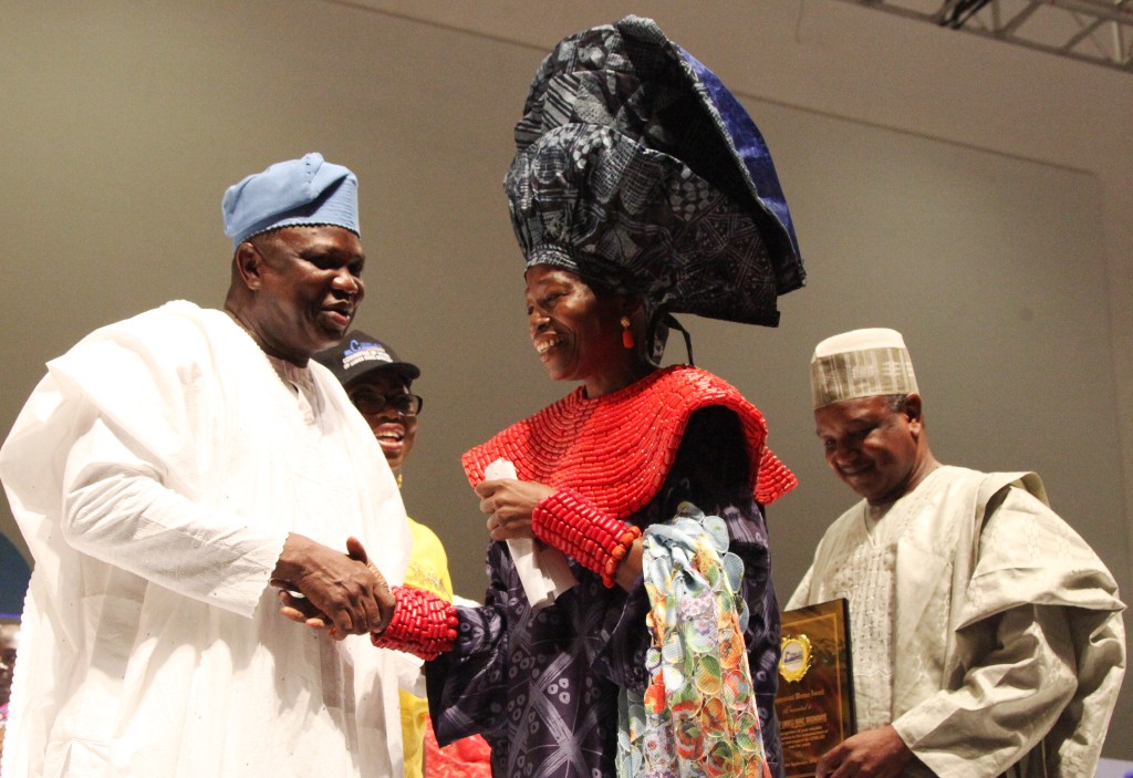 Lagos State Governor, Mr. Akinwunmi Ambode (left) congratulating Winner of the Inspiration Woman of the Year Award, C.E.O, Nike Art Foundation, Chief (Mrs.) Nike Okundaye (2nd right) while Chairman, Committee of Wives of Lagos State Officials (COWLSO), Mrs. Bolanle Ambode (2nd left) and Kebbi State Governor, Alhaji Atiku Bagudu (right) watch with admiration during the opening ceremony of the annual National Women Conference organized by COWLSO, at the Convention Centre, Eko Hotels & Suite on Wednesday, September 16, 2015.
