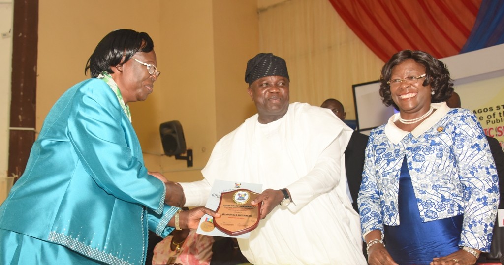 Lagos State Governor, Mr. Akinwunmi Ambode (2nd right); presenting an award to one of the outstanding Public Servants, Senior Cadre, Director of Education/Principal, Ikosi Junior High School, Mrs. Odunuga Elizabeth (left) during the Public Service Day Celebration, at the Adeyemi Bero Auditorium, Alausa, Ikeja, on Thursday, June 23, 2016. With them is the Head of Service, Mrs. Olabowale Ademola (right).