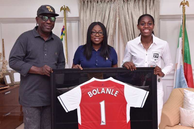 Wife of Lagos State Governor, Mrs. Bolanle Ambode (middle), being presented with an Arsenal Football Club jersey by Super Falcons and Arsenal Ladies FC star, Azeezat Oshoala (right) during Oshoala's courtesy visit to the Wife of the Governor, at Lagos House, Ikeja, on Friday, August 12, 2016. With them is Senior Special Assistant on Sport to the Governor, Mr. Anthony Adeyinka Adeboye (left).