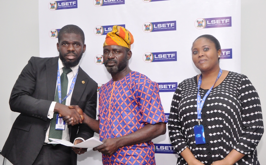 Executive Secretary, Lagos State Employment Trust Fund (LSETF), Mr. Akin Oyebode, presenting a Offer Letter to a successful applicant, Mr. Abdul Rasheed Olakunle Kazeem during the distribution of Offer Letters to beneficiaries of the N25 Billion Employment Trust Fund (ETF) Pilot Scheme at the LSETF Office, Oregun, Ikeja, on Friday, December 30, 2016. With them is Director of Strategy Funding & Stakeholder Engagement, LSETF, Mrs. Abosede Alimi.