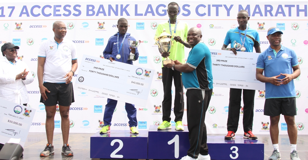 Lagos State Governor, Mr. Akinwunmi Ambode (3rd right), presenting the trophy to the Winner of the 2017 Lagos City Marathon, Abraham Kiptum from Kenya (middle) while 3rd Prize Winner,  Kiprotich Kiroi from Kenya (2nd right); Group Managing Director, Access Bank, Mr. Herbert Wigwe (right);  2nd Prize Winner, Ronny Kipkoech Kiboss from kenya (3rd left); President, Nigeria Stock Exchange, Mr. Aigboje Aig-Imoukhuede (2nd left) and Deputy Governor, Dr. (Mrs) Oluranti Adebule (left) watch with admiration during the 2017 Lagos City Marathon at the Eko Atlantic City, on Saturday, February 11, 2017.