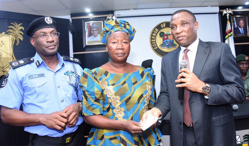  Secretary to the State Government, Mr. Tunji Bello, presenting a cheque to widow of one of the killed Policemen in Ishawo, Ikorodu, Mrs. Temilade Godwin while the Commissioner of Police, Mr. Fatai Owoseni, watches during the presentation of cheques to the Families of the Killed Policemen by Governor Akinwunmi Ambode at the Lagos House, Ikeja, on Monday, May 15, 2017.