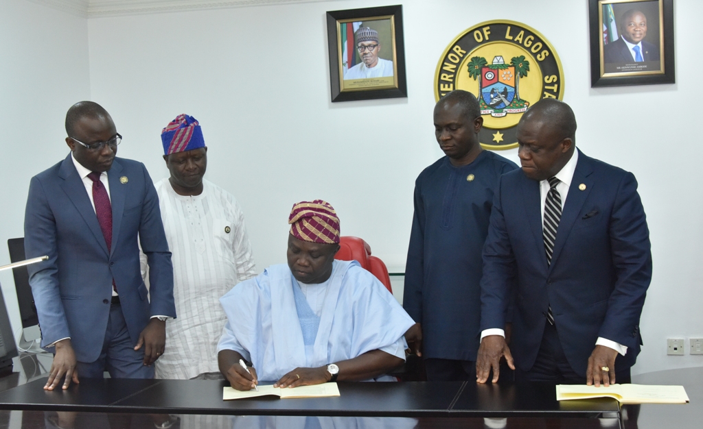 Lagos State Governor Akinwunmi Ambode (middle), signing Seven bills into Law in his Office at the Lagos House, Ikeja, on Thursday, February 8, 2018. With him are Attorney General/Commissioner for Justice, Mr. Adeniji Kazeem (right); Commissioner for Energy & Mineral Resources, Mr. Olawale Oluwo (2nd right); Commissioner for Information & Strategy, Mr. Kehinde Bamigbetan (2nd left) and Commissioner for Finance, Mr. Akinyemi Ashade (left). 