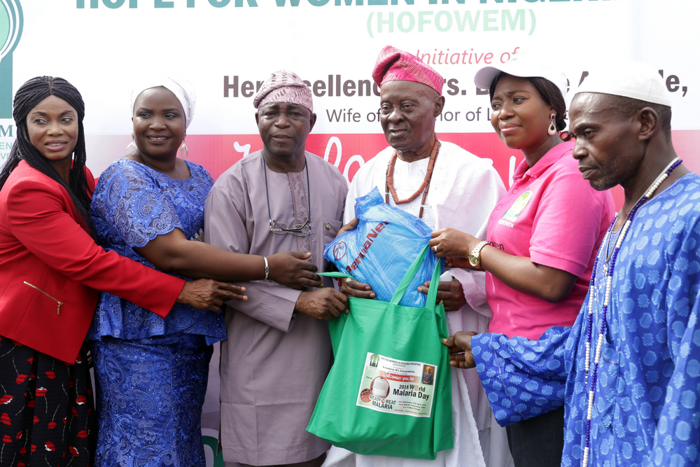 CEO., Hope for Women in Nigeria Initiative (HOFOWEM), Mrs. Oyefunke Olayinka (2nd right); supported by Chairman, Yaba Local Council Development Area (LCDA), Hon. Kayode Omiyale (3rd left) & his wife, Kemi (2nd left), to make symbolic presentation to one of the Chiefs of Makoko Community, Alhaji Ibraheem Aladetan (3rd right), when HOFOWEM (a pet project of the wife of the governor of Lagos State, Mrs. Bolanle Ambode) distributed of over 3000 insecticide-treated nets to Makoko residents, as part of activities to mark the 2018 World Malaria Day, at Yaba, on Wednesday, 25th April, 2018.