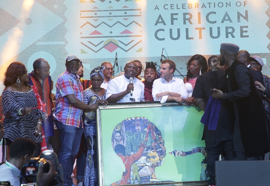 Lagos State Governor, Mr. Akinwunmi Ambode (4th left), presents an art painting to President of France, Mr. Emmanuel Macron (4th right) during the celebration of African Culture at the Afrika Shrine, Ikeja, Lagos, on Tuesday, July 3, 2018. With them: Grammy award-winning musician, Angelique Kidjo (4th left); Special Adviser to the Governor, Lagos Global, Prof. Ademola Abass (3rd left); Afrobeat mucisian, Femi Kuti (2nd left); Mrs. Yemisi Ransome-Kuti (left); Nigerian Music Act, Bankole Wellington ‘Banky W’ (right) and others.